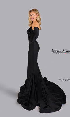A woman poses in the Jessica Angel 2560 Strapless Prom Dress with Gloves, a fitted black gown featuring a long train and beaded bodice, against a gray background for an elegant look.