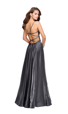 A woman models the La Femme 25670 Long Prom Dress, featuring a floor-length metallic gray design with a strappy open back, as she stands and looks over her shoulder against a white background.