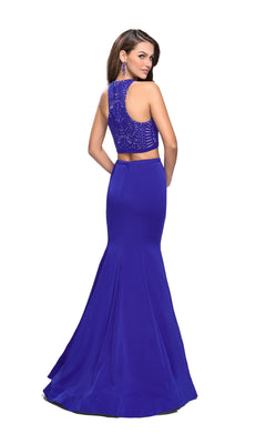 A woman poses against a white background wearing the La Femme 25759 Long Prom Dress, a fitted sleeveless royal blue gown featuring lace back detailing and a flared mermaid skirt.