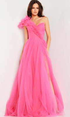 A woman models the Jovani 25919, a bright pink one-shoulder long prom ball gown with tulle and floral appliqué on the shoulder, standing against a plain white background.