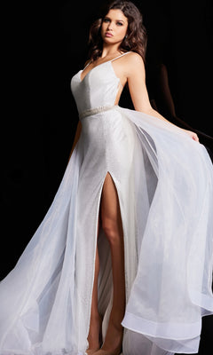 A woman poses against a black background wearing the Jovani Tulle-Overskirt Beaded-Net Prom Dress 25990, featuring a sleeveless white design with a high slit, mesh texture, fitted bodice, and flowing sheer train.