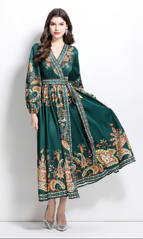 Woman in a forest green Long-Sleeve Paisley-Print Casual Maxi Wrap Dress stands against a white background, holding one side of the skirt.