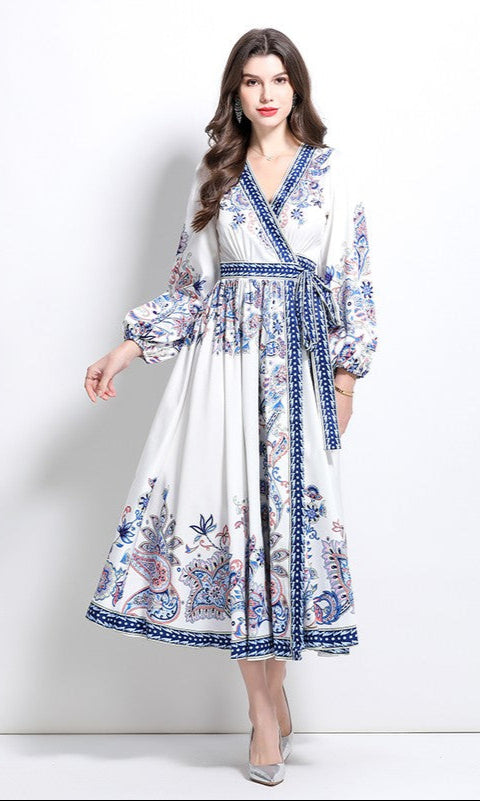 A woman wears the Long-Sleeve Paisley-Print Casual Maxi Wrap Dress in white floral, styled as a casual A-line dress, standing against a plain white background.