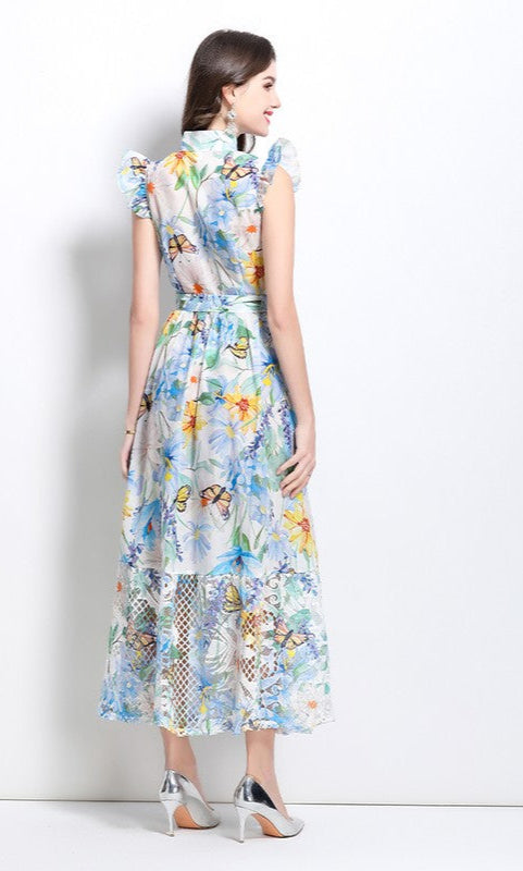 A woman faces away, wearing an A-Line Floral-Print Casual Maxi Dress with buttons and silver heels against a white background.