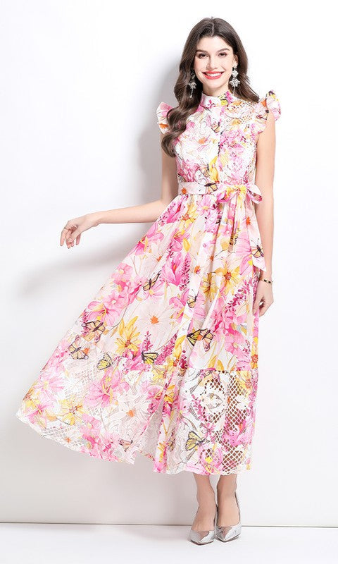 Woman models the High-Neck Long Print Casual Dress with Cap Sleeves in Pink Multi, featuring an ankle-length floral design, against a white background. She pairs it with light-colored heels.