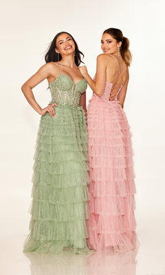 Two women stand side by side, smiling, in floor-length tiered dresses—one wears the Cecilia Couture 2613 long light green prom dress with a fitted bodice, and the other is in pink with a lace-up open back.