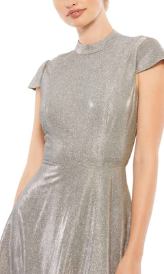 A woman wearing the Short Wedding Guest Dress 26151 by Mac Duggal, featuring a silver metallic finish, fitted bodice, flared skirt, and short sleeves—ideal for festive occasions.