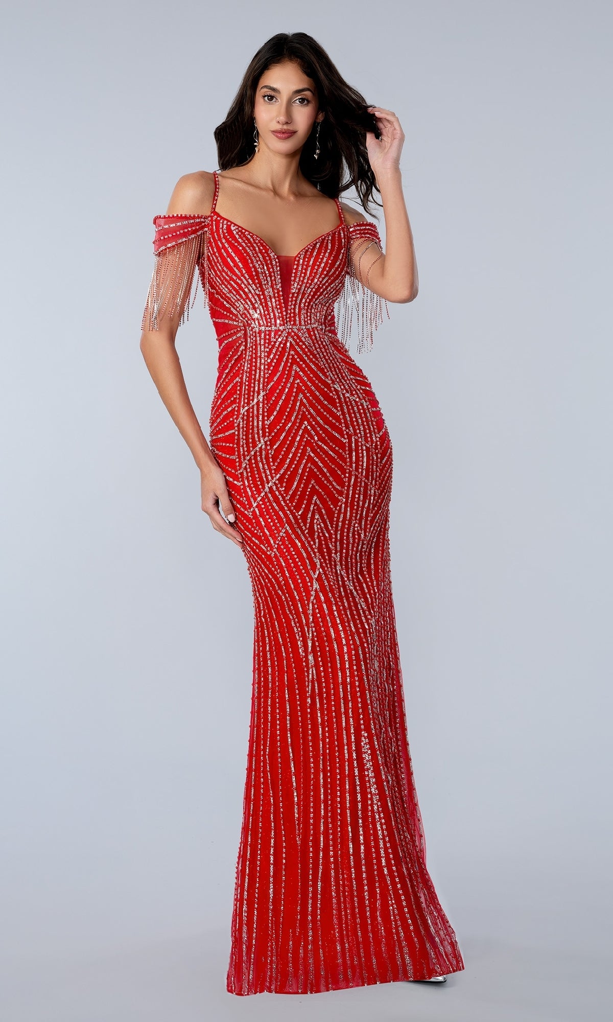 A woman models the Stella Couture 26164 long red prom dress, featuring a fitted off-the-shoulder design with silver beaded embellishments and fringe, against a plain light gray background.