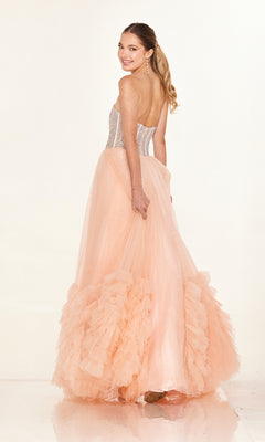 Woman in the Cecilia Couture 2617 long prom dress, featuring a strapless A-line tulle skirt and fitted semi-sheer bodice, smiling over her shoulder against a light background.
