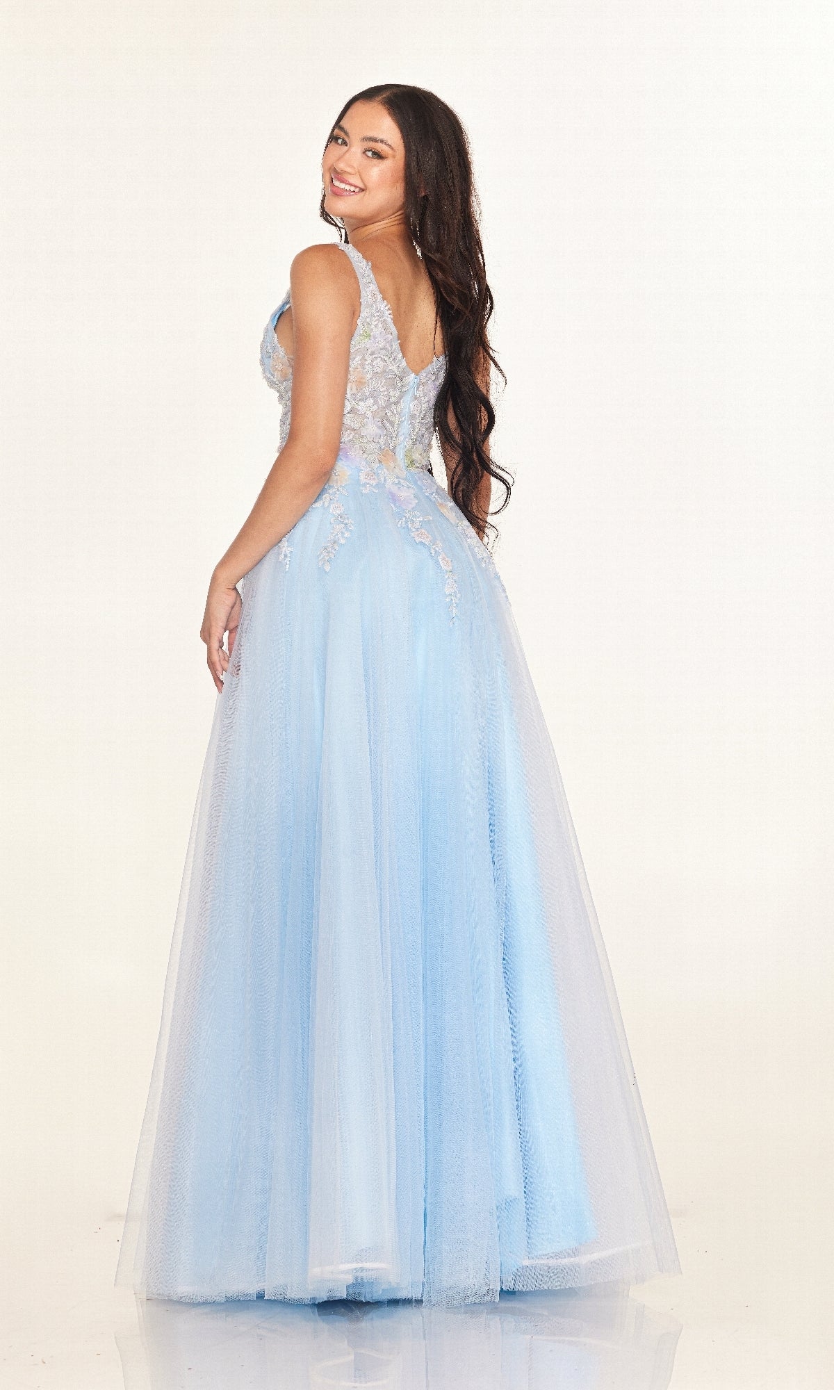 A woman with long brown hair models the Cecilia Couture 2619 long prom dress in light blue, featuring sheer lace details and delicate floral embroidery, smiling over her shoulder against a plain white background.
