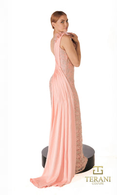 A woman stands on a black platform wearing the Long Formal Dress: Terani 261E6257, featuring a one-shoulder lace design with 3D floral appliques and a long draped train. The Terani Couture logo appears in the bottom right corner.