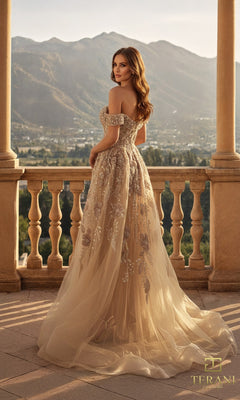 A woman in a Terani 261M6435 long formal dress stands on a balcony, her embellished beige gown flowing elegantly with mountains and lush greenery behind her.