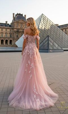 A woman in a Long Formal Dress: Terani 261M6435 stands outdoors on a tiled surface, facing away, with the Louvre Pyramid and historic Louvre building in the background.