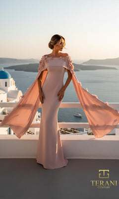 A woman in a pale pink, floor-length crepe dress with cape sleeves (Long Formal Dress: Terani 261M6687) stands on a balcony overlooking the sea and white buildings, with the "Terani Couture" logo in the corner.
