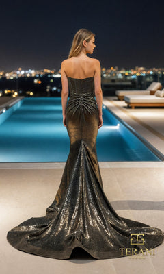 A woman in the Terani 261P6160 long formal dress, crafted from shimmering jersey, stands by an illuminated pool at night with city lights sparkling in the background.