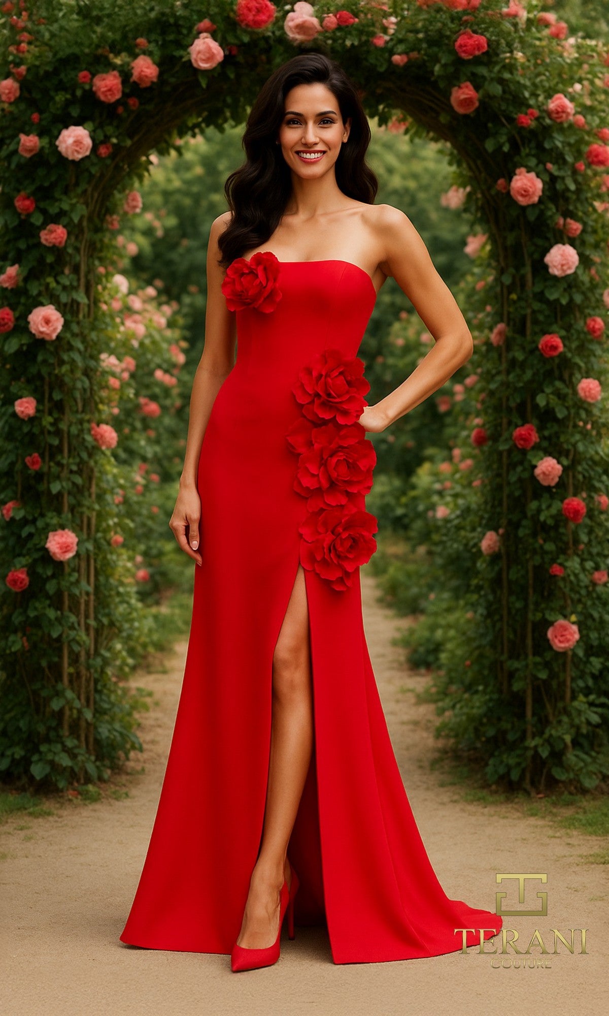 A woman stands outdoors beneath a rose-covered archway, wearing the red Long Formal Dress Terani 261E6698, which features a strapless design and 3D floral appliques.