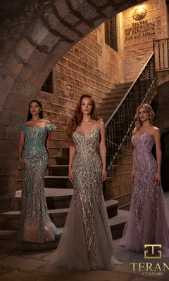 Three women in ornate, shimmering evening gowns, including the Terani 261GL6373 long formal dress, stand on stone steps inside a historic building with arched ceilings and a Terani Couture logo in the corner.