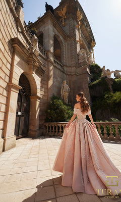 A woman wearing the Long Formal Dress: Terani 261GL6659 stands before a grand stone building decorated with classical statues and intricate architectural details.