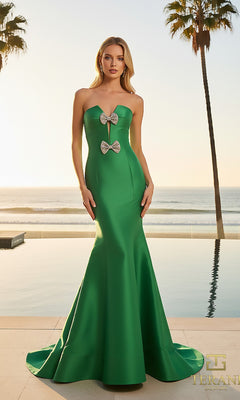A woman in the Terani 261P6075 long formal dress, featuring a strapless design with bow accents and a mermaid silhouette, stands outdoors by a pool with palm trees and the ocean behind her.