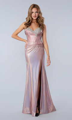 A woman poses against a plain light background in the Stella Couture 26200 long prom dress in rose, featuring a shiny, form-fitting metallic style with a sweetheart neckline, jeweled corset bodice, ruched waist, and thigh-high slit.