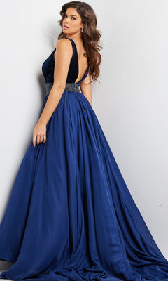 Woman modeling the Jovani Belted Long Chiffon Prom Ball Gown 26201—a sleeveless, deep blue A-line formal dress with a beaded waistband and floor-length skirt—stands against a plain light background.