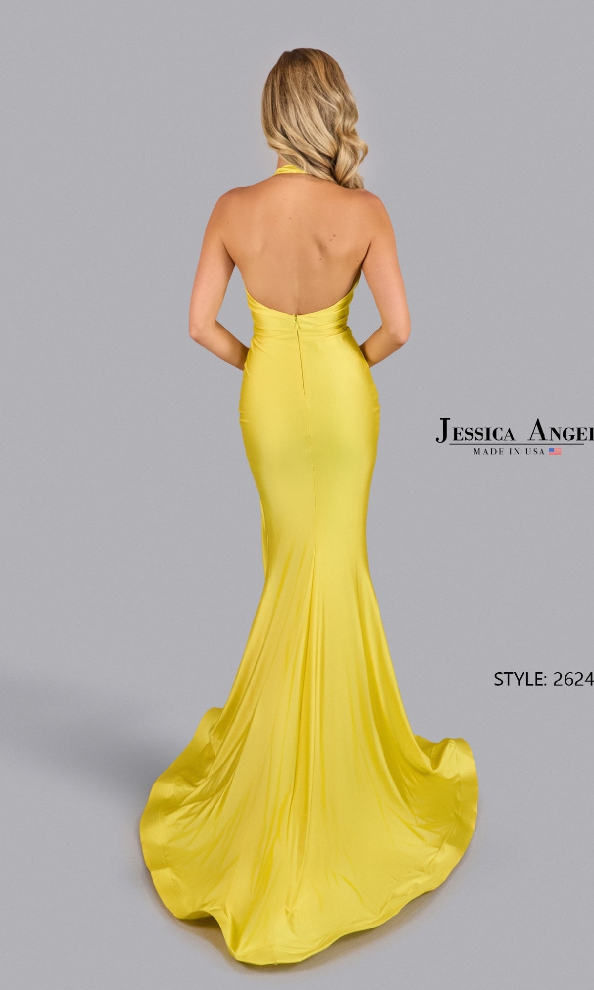 A woman with wavy blonde hair models the Jessica Angel 2624 Long Halter Prom Dress in yellow, featuring a fitted silhouette, deep v-neck, and flowing train against a plain gray background.