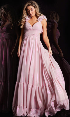 A woman in the Jovani Ruffle-Strap Long Metallic Prom Dress 26248, a shiny light pink gown with ruffled shoulder straps, stands against a dark background holding one side of her dress.