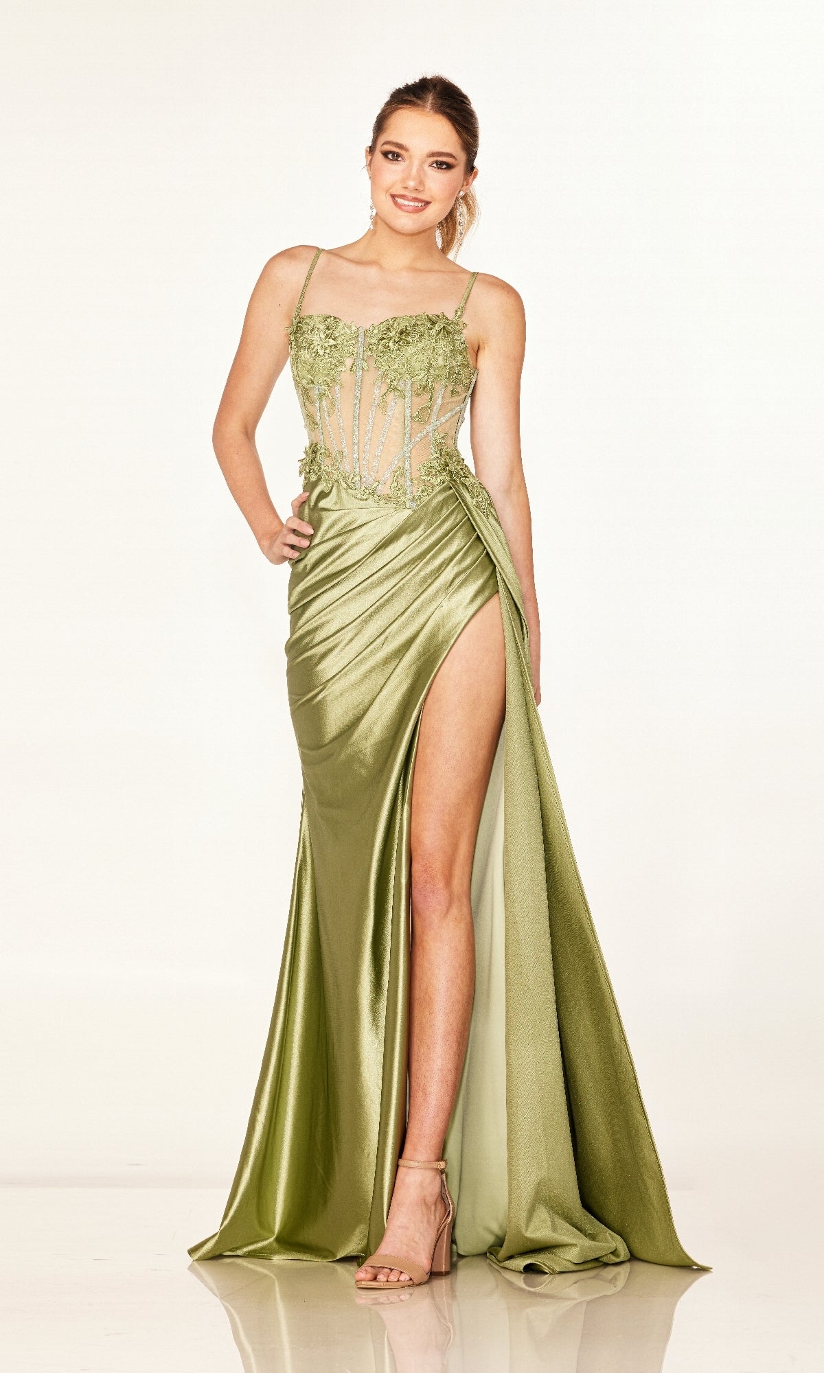A woman models the Cecilia Couture 2627 long prom dress in light green satin, featuring a high leg slit, sheer floral bodice, and strappy heels, posed against a plain white background.