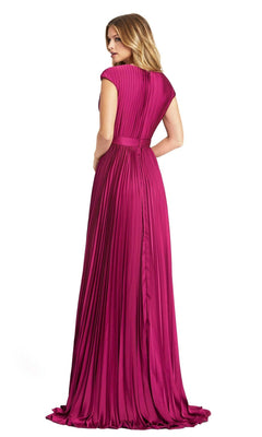 A woman stands facing away, wearing a floor-length magenta Mac Duggal 26285 V-Neck Belted Pleated Formal Dress with short sleeves.