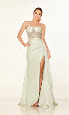 A woman smiles in the Cecilia Couture 2628, a floor-length light green prom dress with a slit and beaded embellishments, posing with one hand on her hip against a plain background.