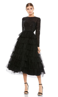 A woman wears the Mac Duggal 26299 knee-length wedding guest dress—a black sequin A-line design with long sleeves and a layered tulle skirt—paired with black high-heeled sandals, set against a white background.