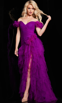 A woman wears the Jovani Ruffled Off-Shoulder Long Prom Dress 26312 in vibrant purple with floral accents, standing against a black background. The elegant ruffled A-line gown highlights formal style as she touches her hair.