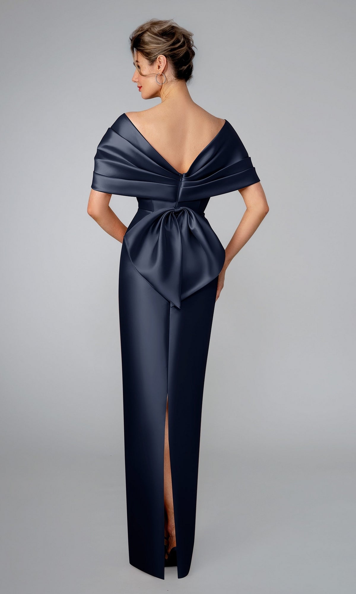 Back view of the navy Long Formal Dress: Stella Couture 26312, featuring a floor-length hem, off-the-shoulder neckline, large waist bow, and a back slit.