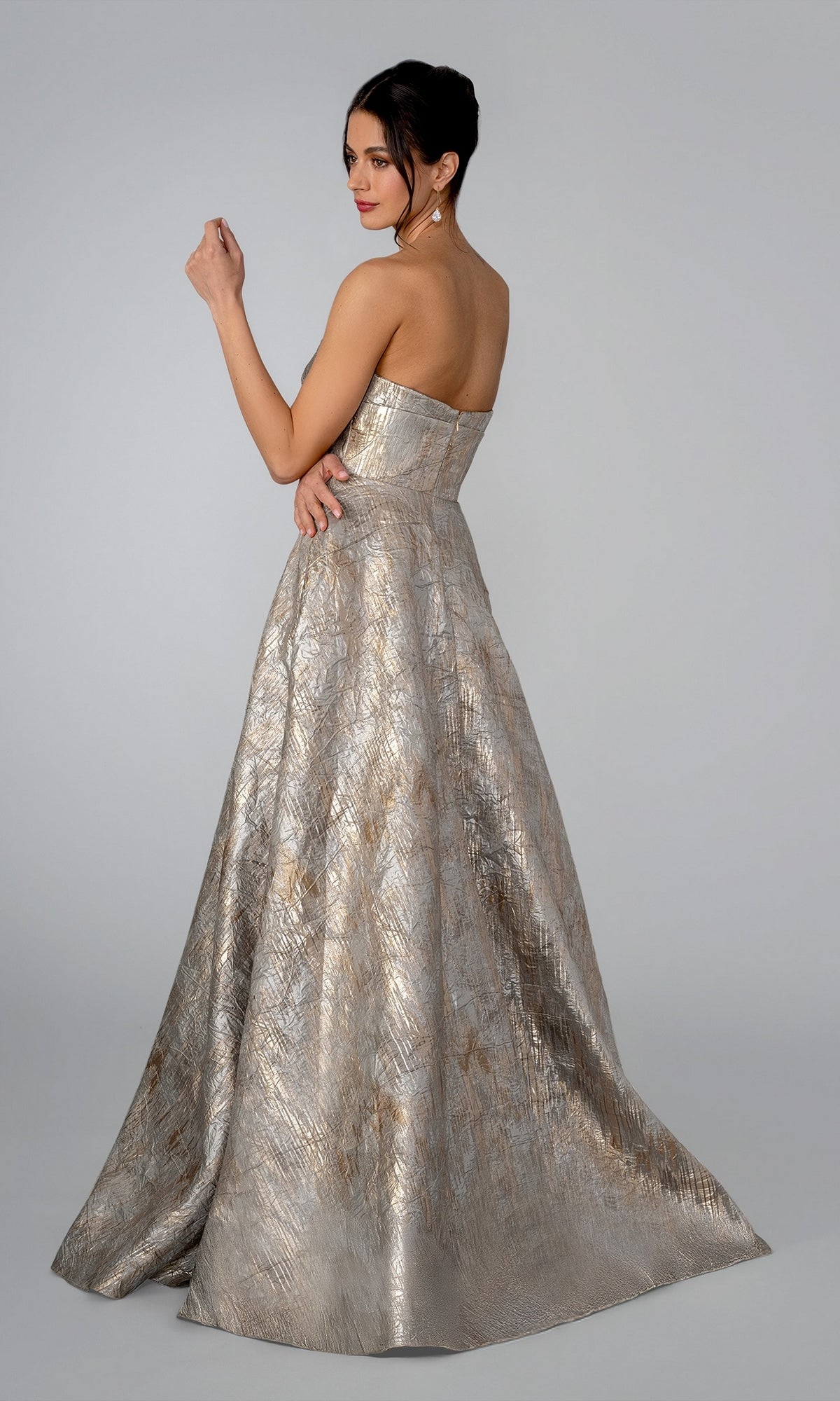 A model wearing the Long Formal Dress: Stella Couture 26316, a strapless gold evening gown with a metallic, textured finish and an A-line skirt.