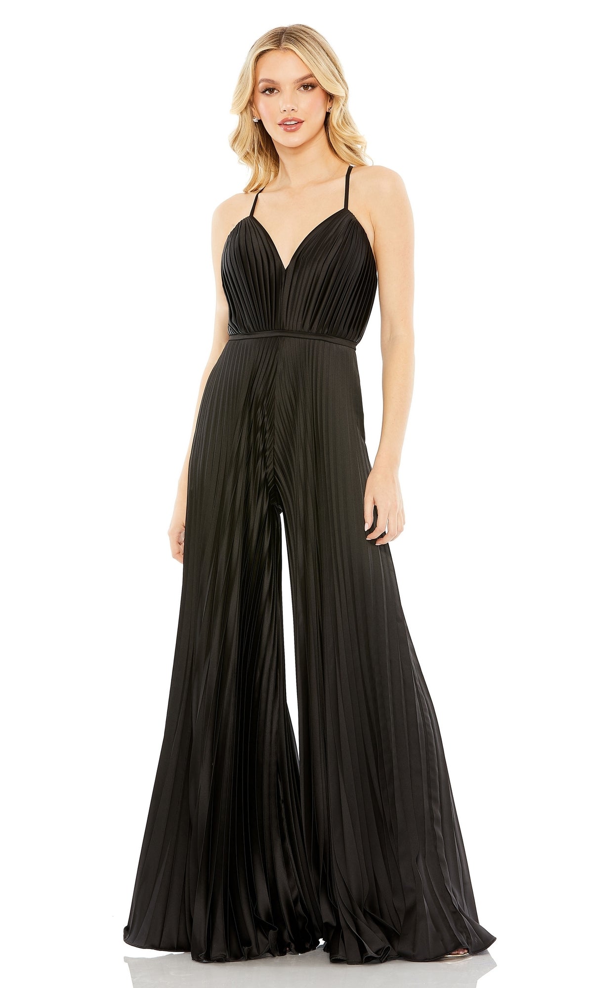 A woman models the Mac Duggal Pleated Wide-Leg Formal Jumpsuit 26319, featuring a black pleated design, thin shoulder straps, wide legs, and a V-neckline against a white background.