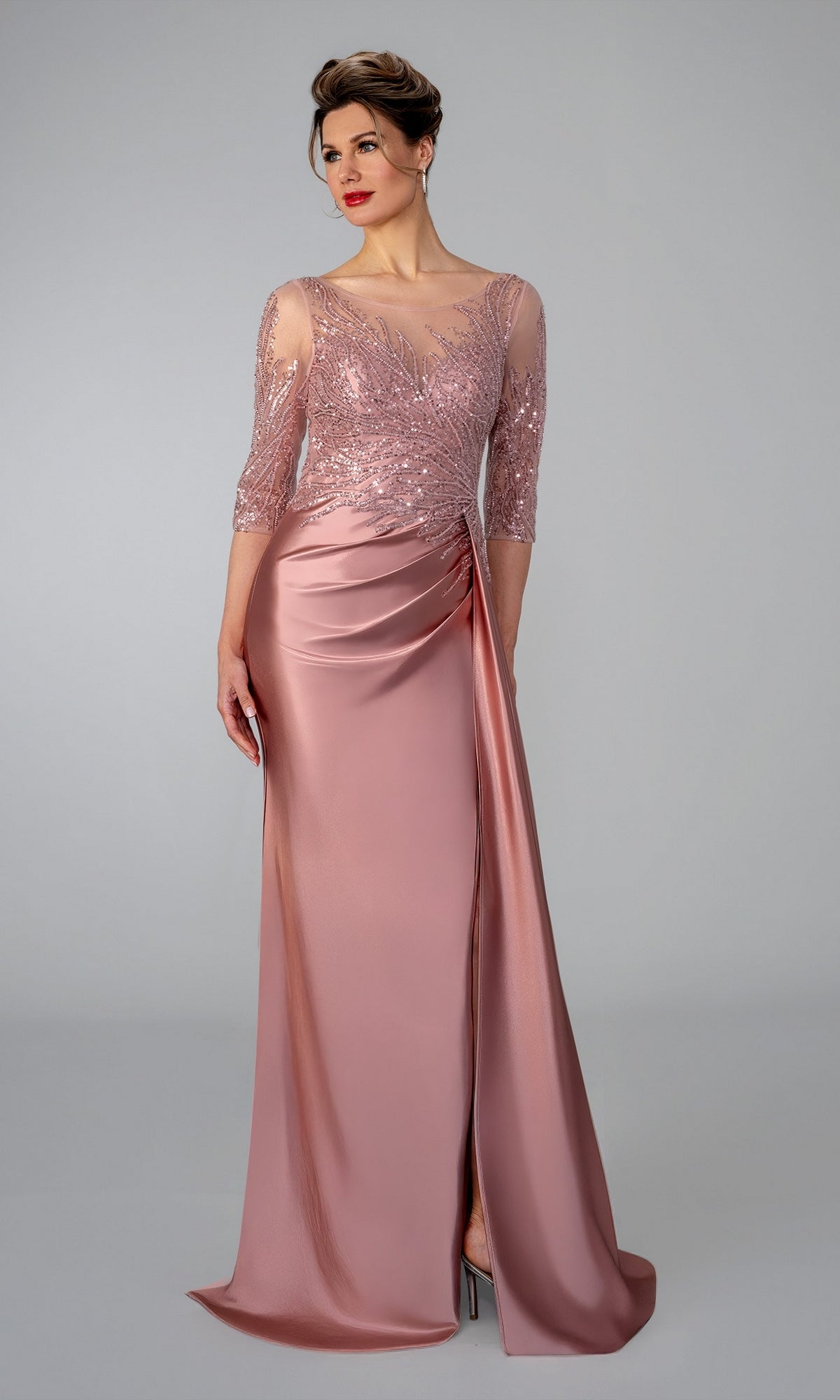 Stella Couture 26320 rose-colored evening gown with a sheer, beaded lace bodice, three-quarter sleeves, and a draped skirt with a high slit.