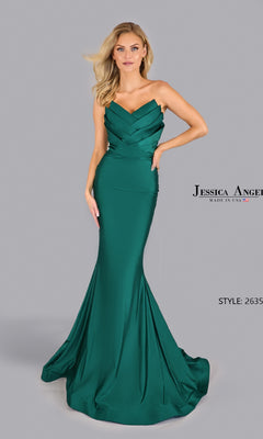 A woman models the Pleated Strapless Prom Gown: Jessica Angel 2635 in emerald green, standing poised against a plain gray background.