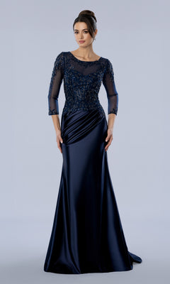 The Stella Couture 26380 is a navy blue mother of the bride evening gown with a floor-length silhouette, sheer beaded bodice, and three-quarter length sleeves.