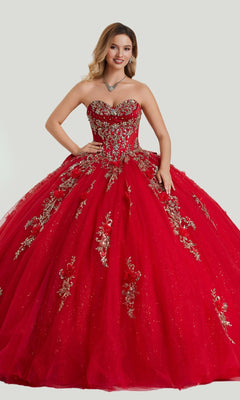 A woman stands against a light background wearing the Quinceanera Dress 26414 by Stella Couture, a strapless red ball gown embellished with gold appliques and paired with a jeweled necklace.