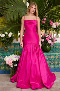 A woman poses before lush greenery and blooms, wearing the Ava Presley 26422 drop-waist mermaid prom gown in bright pink, featuring a fitted bodice and flared skirt.