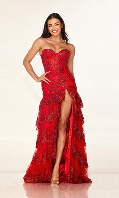 Woman smiling in the Cecilia Couture 2642, a long prom dress with a strapless fitted corset bodice, high slit, and tiered layered skirt featuring intricate beadwork and lace details.