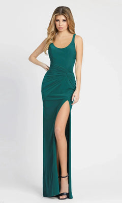 Woman in an emerald Mac Duggal 26434 long formal dress featuring a sleeveless design, ruched detailing, and high-leg slit, posed against a white background.