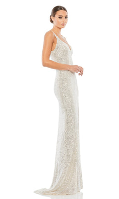 A woman stands in profile against a white background wearing the Mac Duggal 26443 Sexy Long Sequin Formal Dress, a floor-length silver gown with thin straps.
