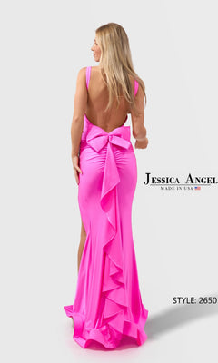 A woman models the Jessica Angel 2650 long prom dress in bright pink stretch jersey, featuring a sleeveless design with a large bow and ruffle detailing down the back, posing with her back to the camera.