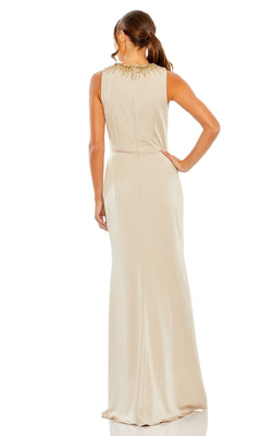 A woman stands with her back to the camera, wearing the Mac Duggal Long Formal Dress 26516, a sleeveless beige gown with a high neckline and gold embellishments accentuating the collar.