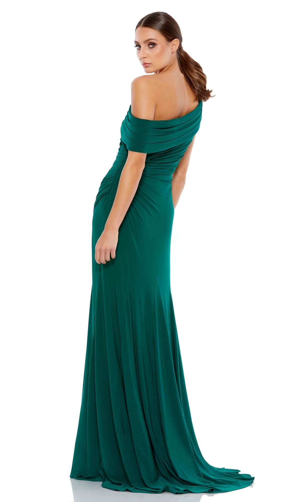 A woman stands against a white background, looking over her shoulder in the Mac Duggal 26517 one-shoulder long prom dress.