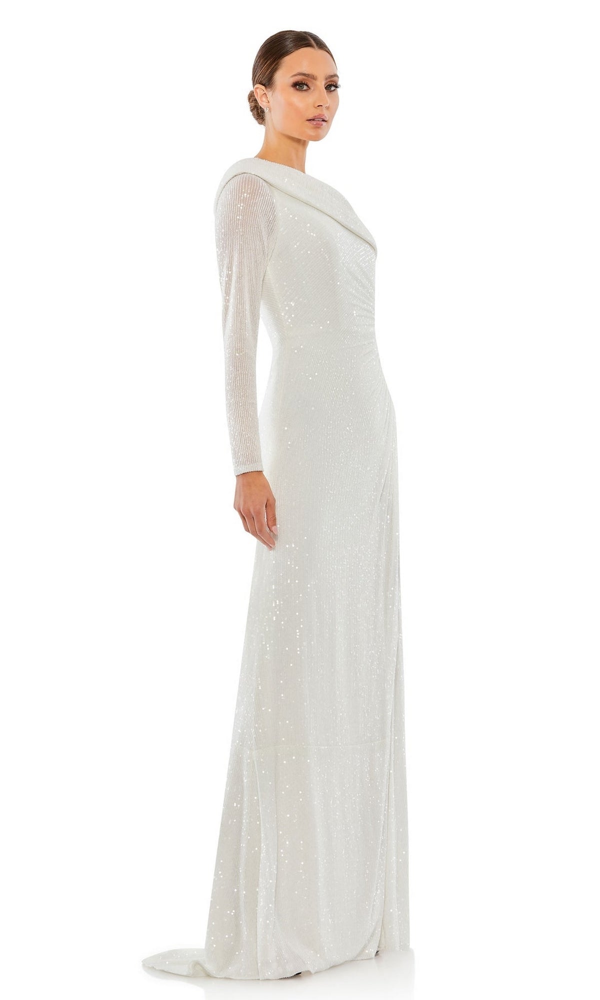A woman stands in profile wearing the Mac Duggal 26571 One-Sleeve Sequin Formal Dress—a long, white gown adorned with shimmering sequins, featuring a single sleeve and a slight train.