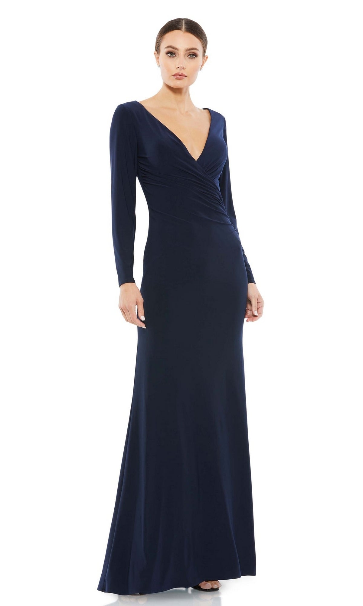 A woman wears the Mac Duggal 26573 long sleeve formal gown—a navy blue, V-neck, floor-length dress with a fitted silhouette for a refined, modest evening look.