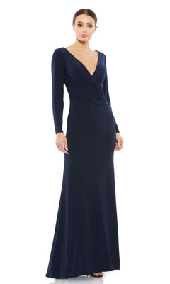 A woman wears the Mac Duggal 26573 long sleeve formal gown—a navy blue, V-neck, floor-length dress with a fitted silhouette for a refined, modest evening look.