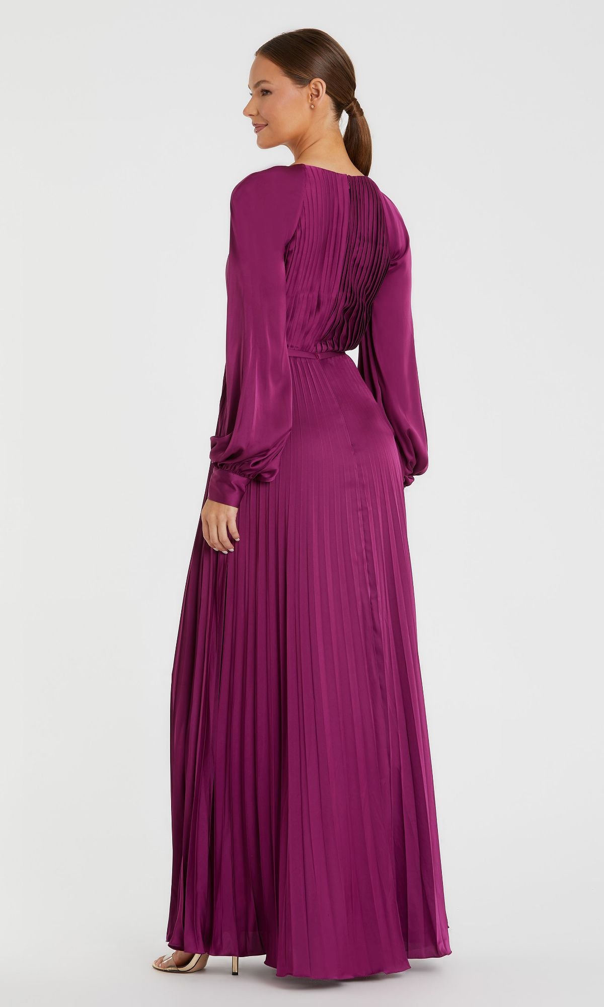 A woman in profile, wearing the Mac Duggal 26590 long sleeve magenta formal dress with pleats and an A-line silhouette, looks over her shoulder.
